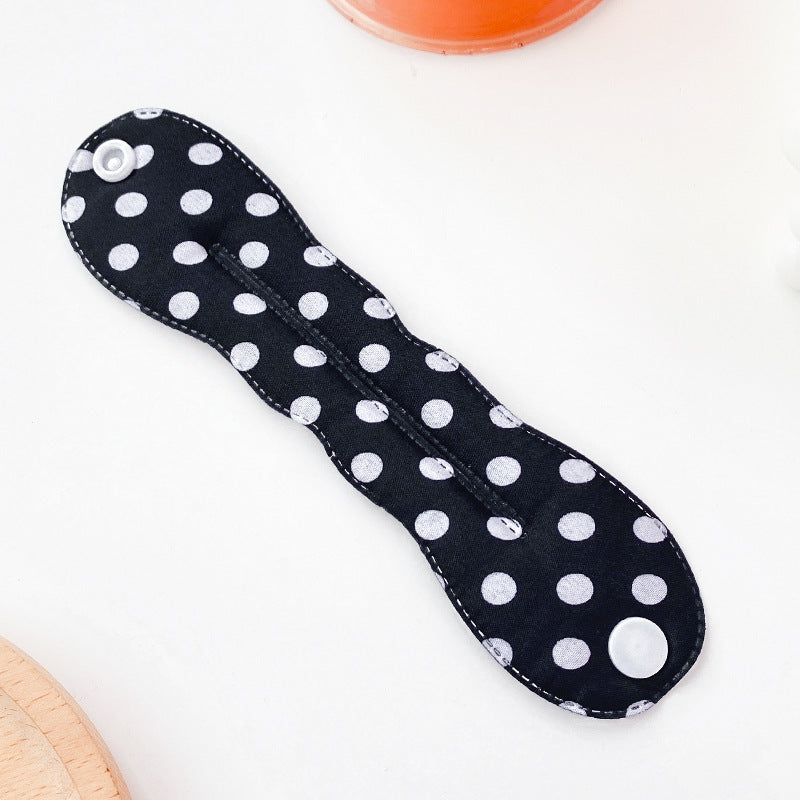 Black cloth pad with white polka dots on a white background