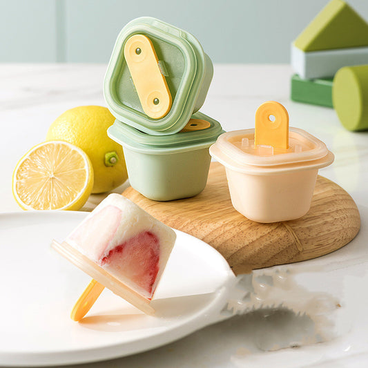 Popsicle mold with a popsicle on a wooden board, surrounded by lemons.