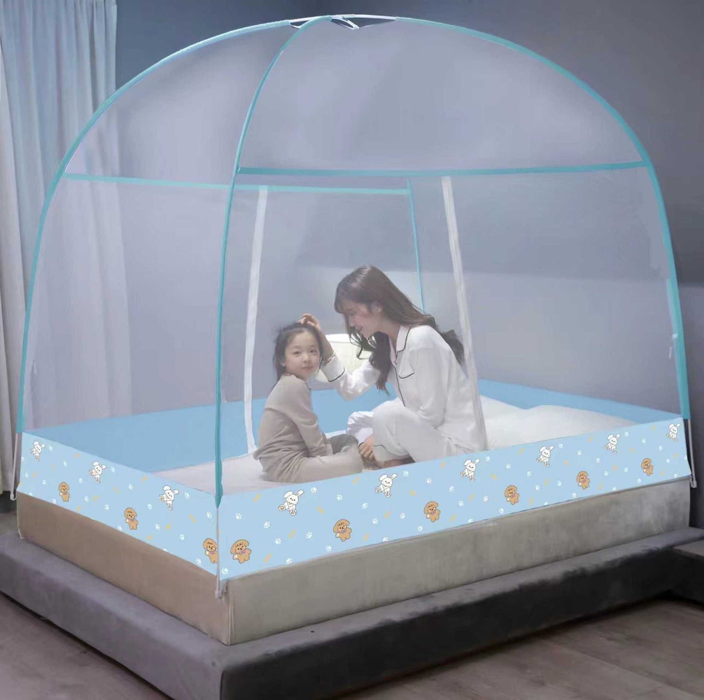 Mother and child inside a transparent bed canopy with floral patterns on a bed.