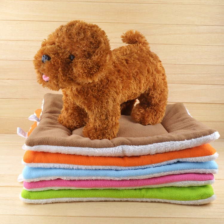 Plush toy dog standing on a stack of colorful towels with a wooden background