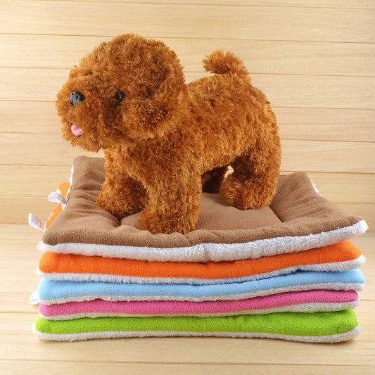 Plush toy dog standing on a stack of colorful towels with a wooden background