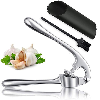 Garlic press with a brush and garlic cloves on a white background
