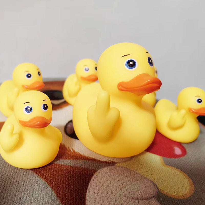 Yellow rubber duck with a baby on its back on a textured surface