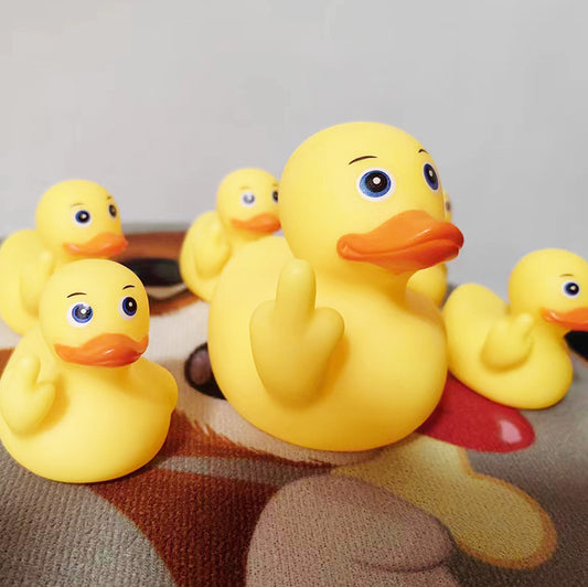 Yellow rubber duck with a baby on its back on a textured surface