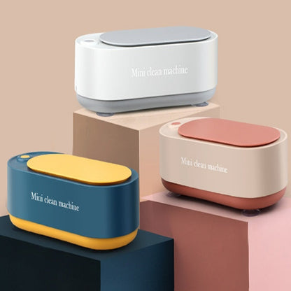 Three mini cleaning machines on geometric platforms with a beige background