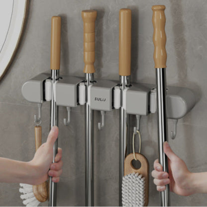 Mop and broom holder with cleaning tools on a gray wall.
