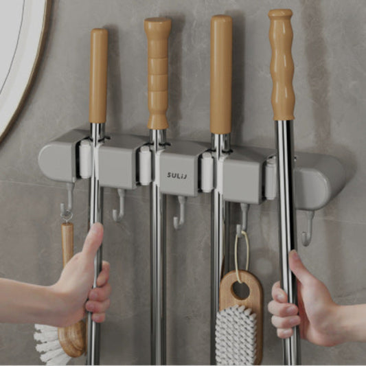 Mop and broom holder with cleaning tools on a gray wall.