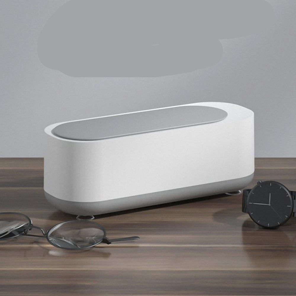 White electronic device on a wooden surface with text describing its features