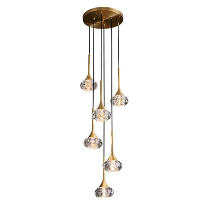 Gold pendant light fixture with crystal-like glass shades on a white background