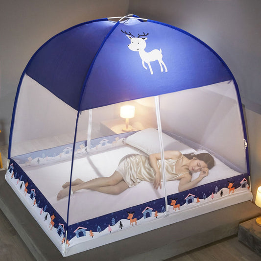 Child's bed with a blue canopy featuring a deer design, lit by a lamp in a cozy room.