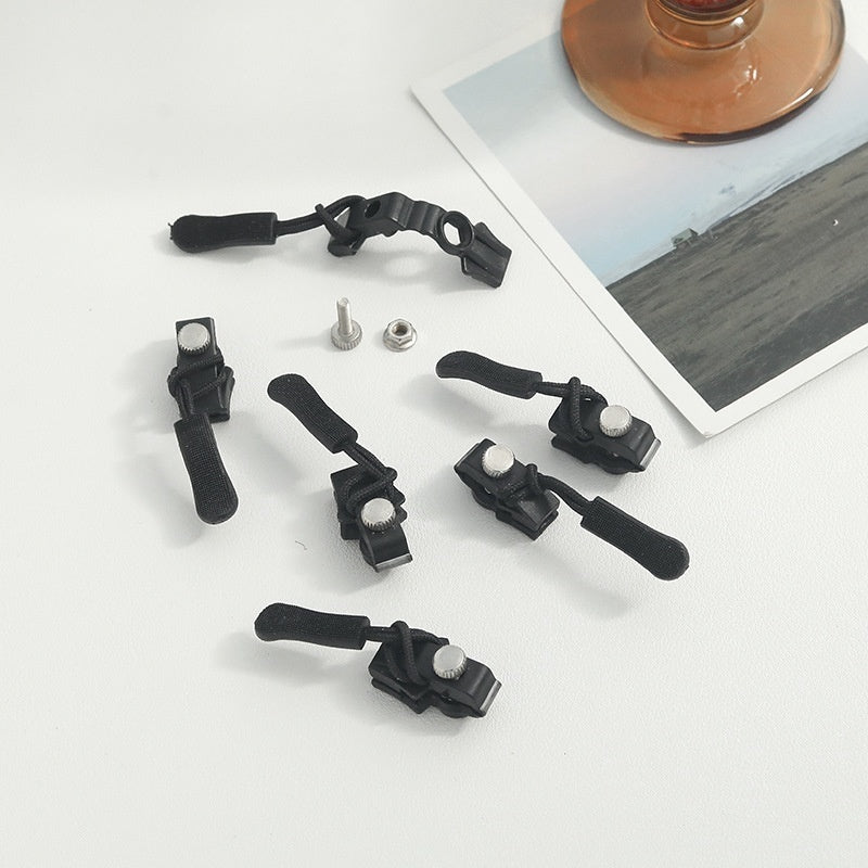 Set of black camera accessories on a white surface with a photo in the background.