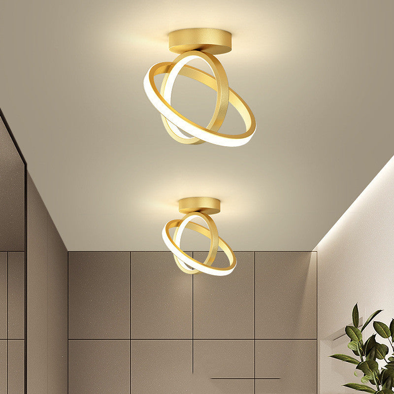 Modern ceiling light fixture with gold finish and circular design in a room setting.