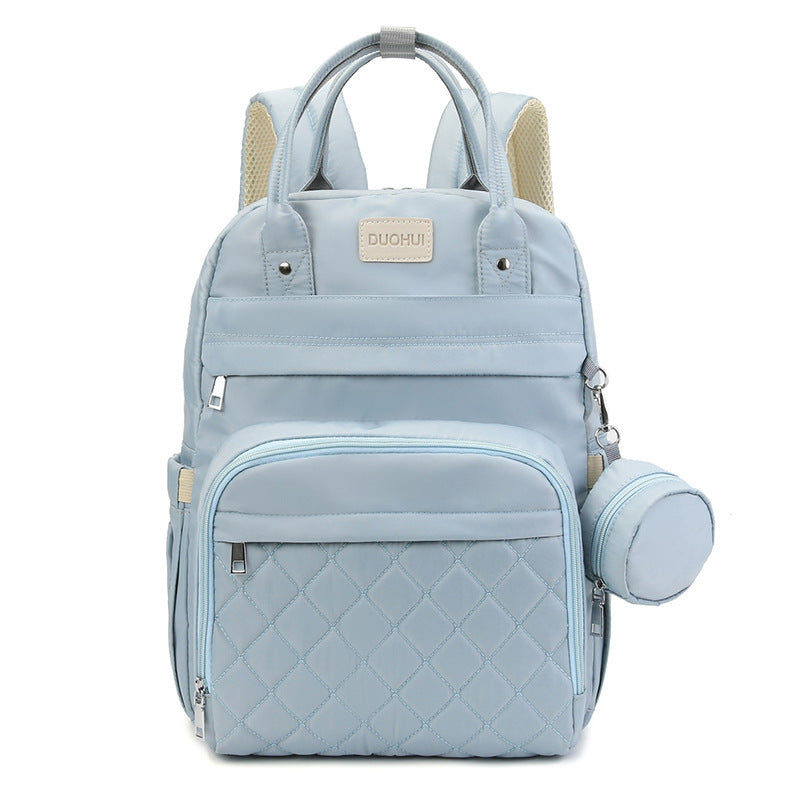 Light blue backpack with quilted design and baby bottle holder on a white background