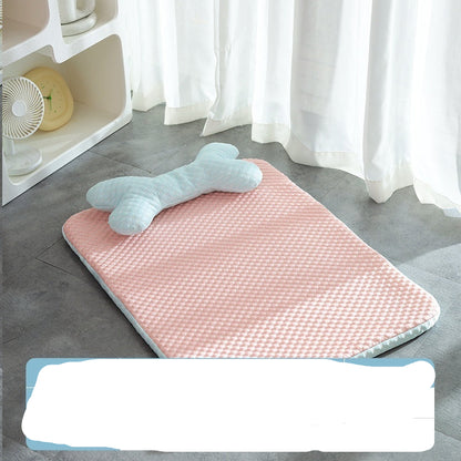Pink bath mat with a bone-shaped towel on a gray floor, next to a white shelf with a fan and yellow item.