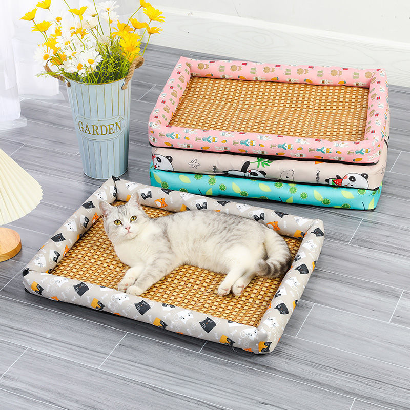 Cat lying on a patterned pet bed with other beds stacked in the background.
