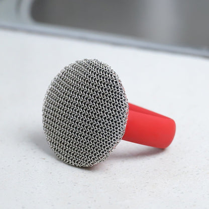 Metal scrubber with red handle on a white surface