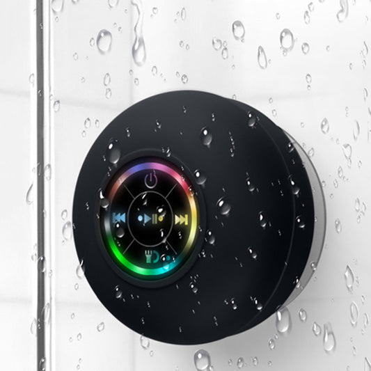 Black circular device with colorful display on a wet glass surface