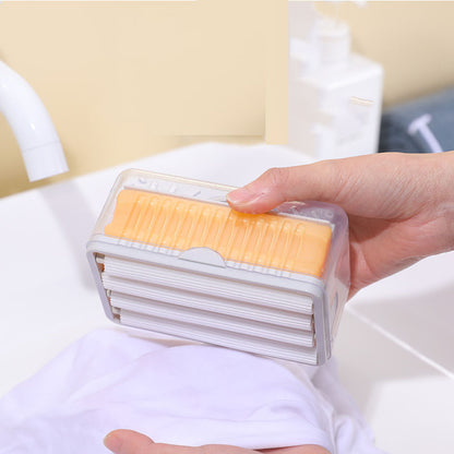 Hand holding a transparent container with yellow and white items against a light background