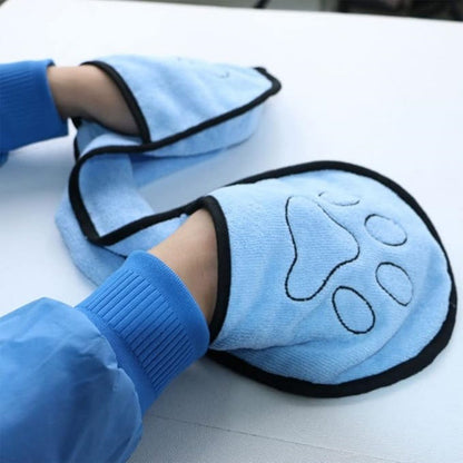 Blue pet grooming mitts with paw design on a white surface