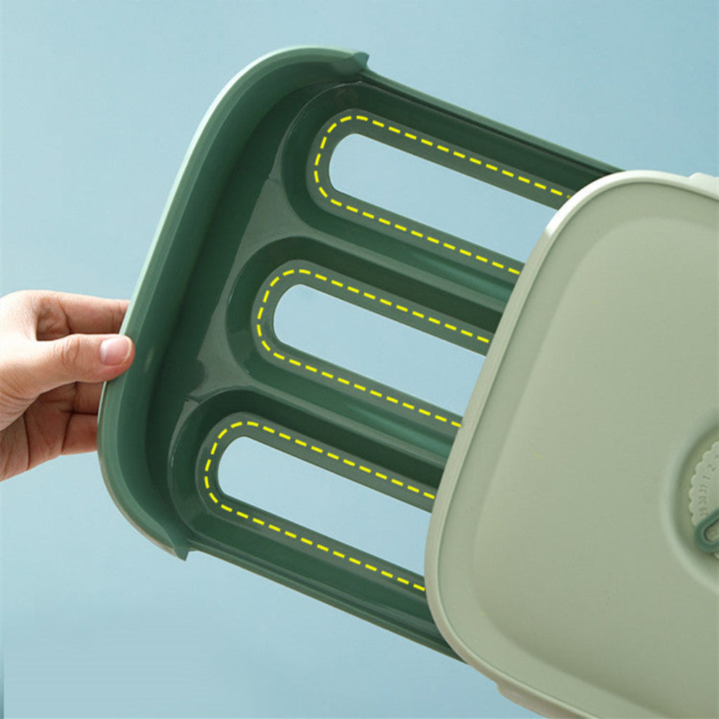 Green and beige plastic tray with cut-out sections on a light blue background