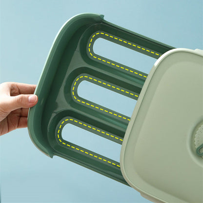 Green and beige plastic tray with cut-out sections on a light blue background