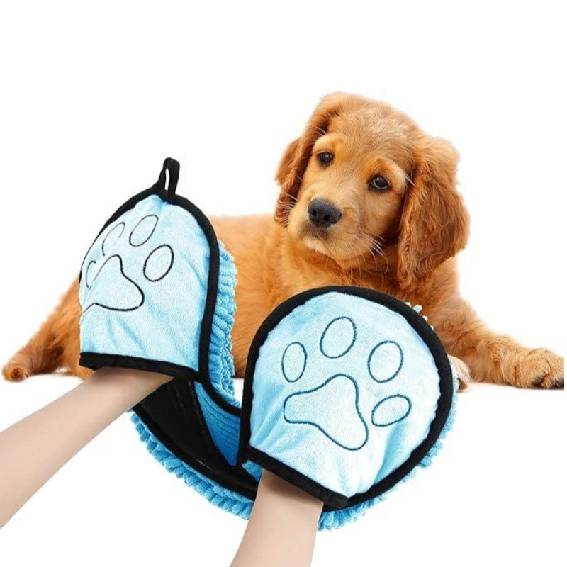 Dog wearing a blue paw-patterned coat with a paw-shaped towel held by a person.