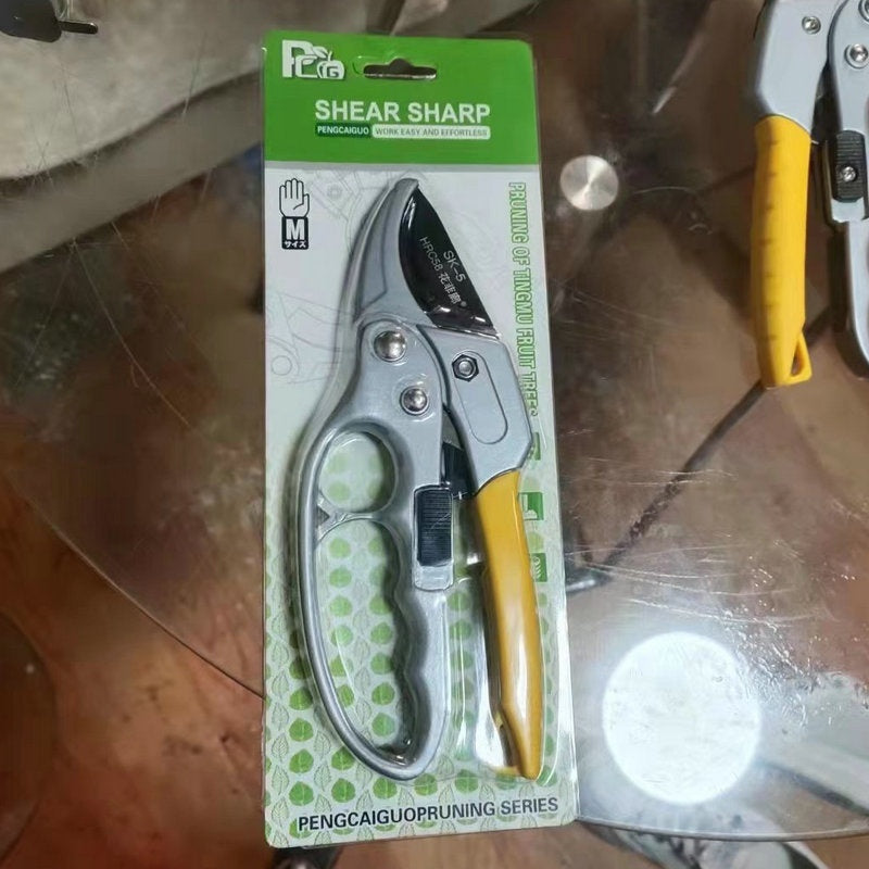 Pruning shears with yellow handles on a green packaging labeled 'Shear Sharp' on a reflective surface.