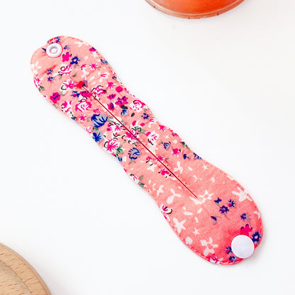 Floral-patterned sanitary pad on a white background