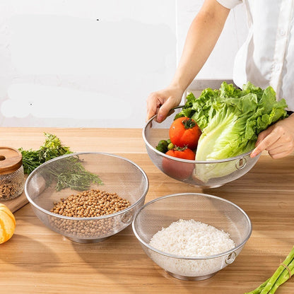 Person holding a colander with vegetables over a bowl of rice on a wooden table.