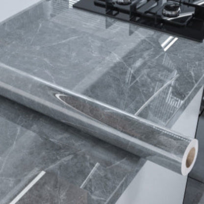 Roll of gray marble contact paper on a kitchen countertop