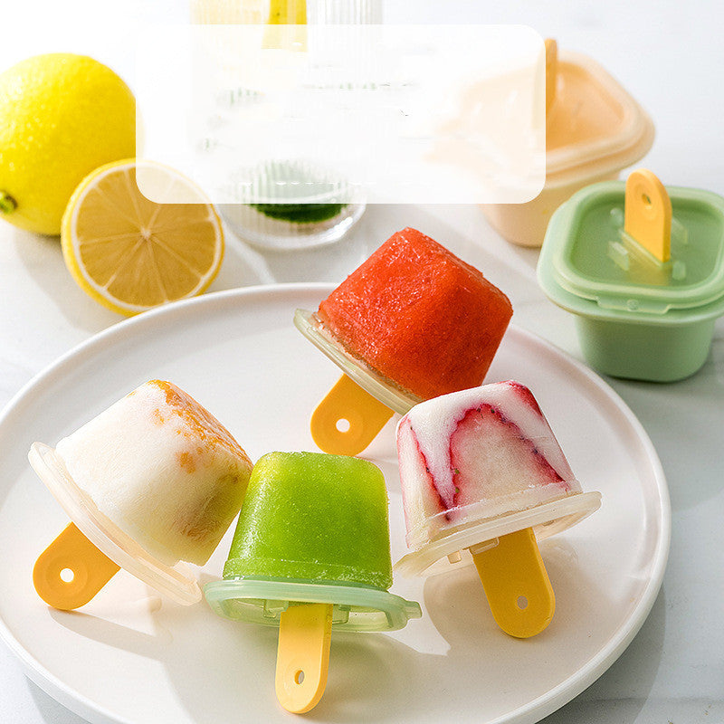 Assorted fruit popsicles on a white plate with lemons in the background