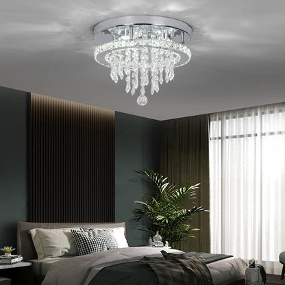 Chandelier hanging above a bed in a modern bedroom with dark walls and a large window.