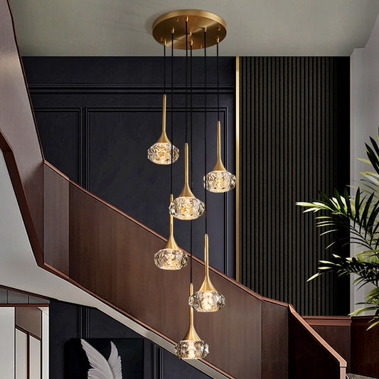 Modern chandelier with gold finish and crystal-like glass in a stylish interior setting.