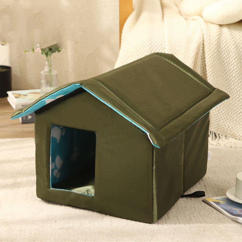 Green pet house on a bed with a blurred background